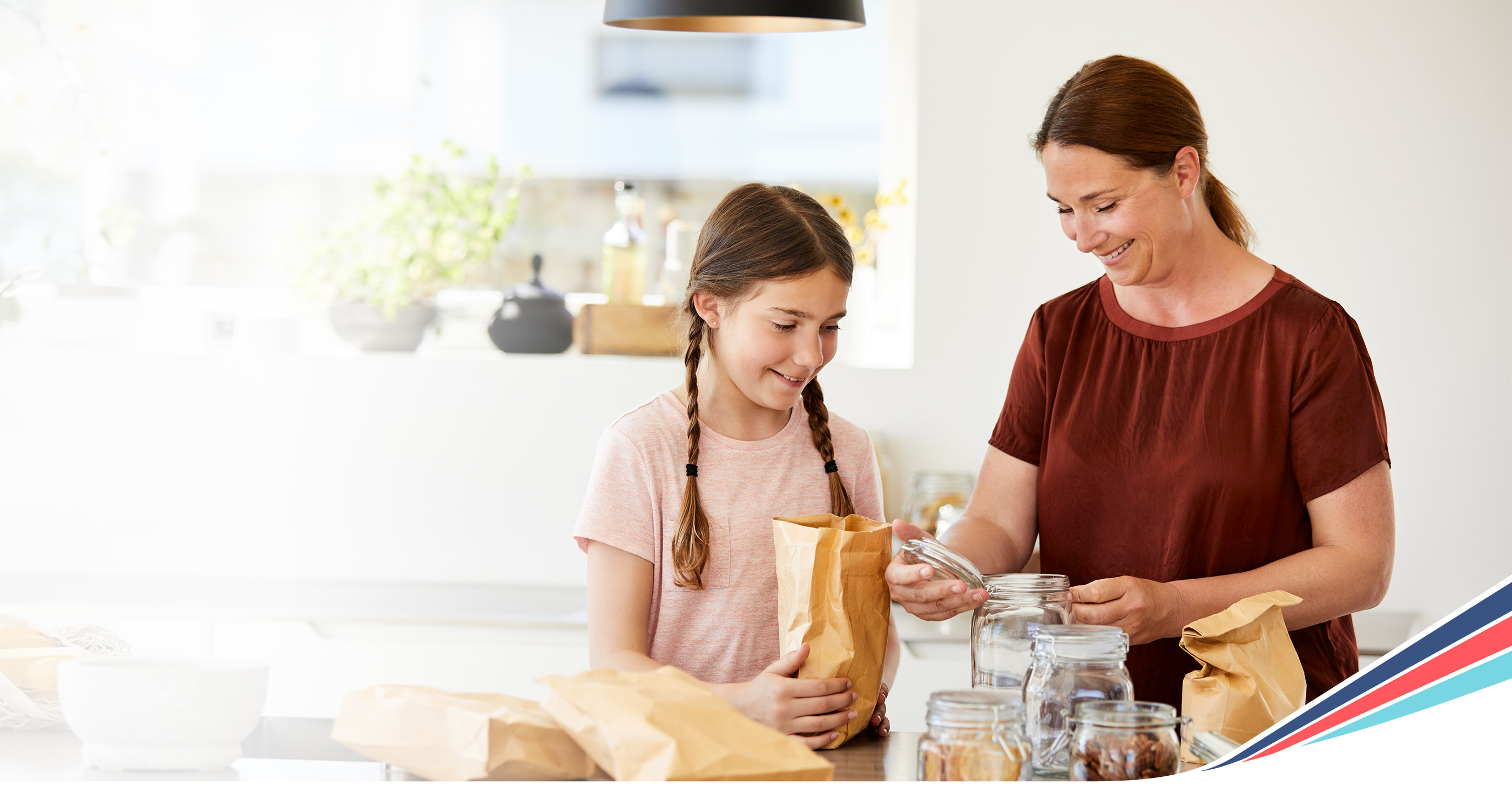 Mother and daughter packing a lunch together in the kitchen
